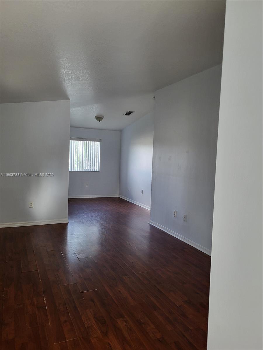 2920 Southeast 12th Road, Unit 20130 Homestead, FL 33035 - Photo 10 of 11 an empty room with wooden floor and windows