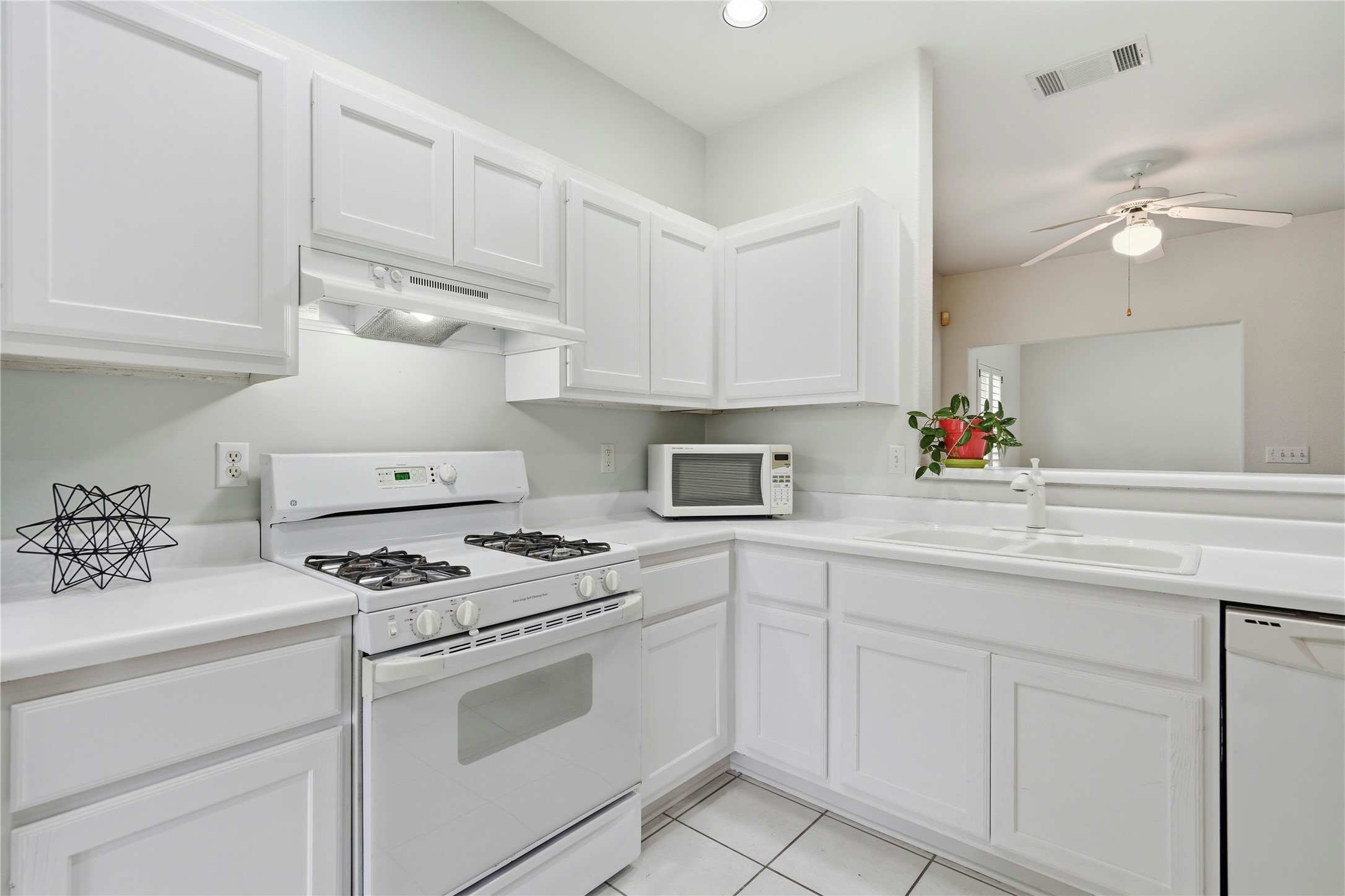 117 Whitewing Way Georgetown, TX 78633 - Photo 7 of 27 A well-lit kitchen with classic white cabinetry and practical tile flooring.