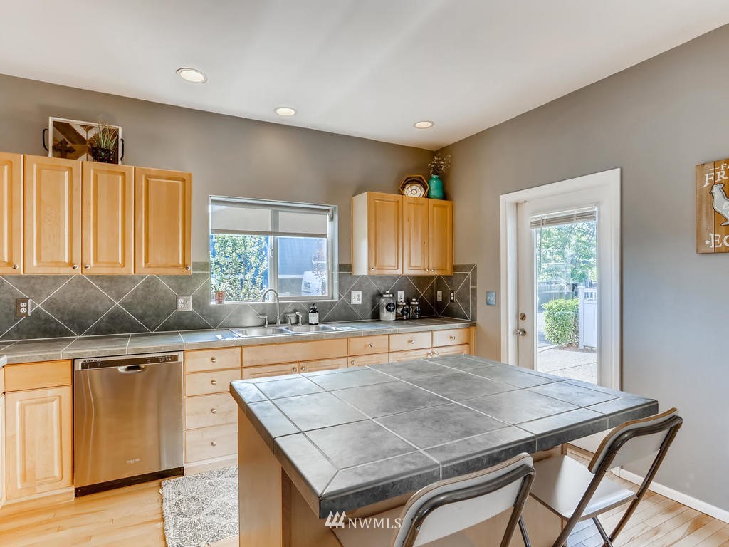 16624 Southeast 169th Street Renton, WA 98058 - Photo 7 of 21 a kitchen with a stove a sink a refrigerator and wooden cabinets