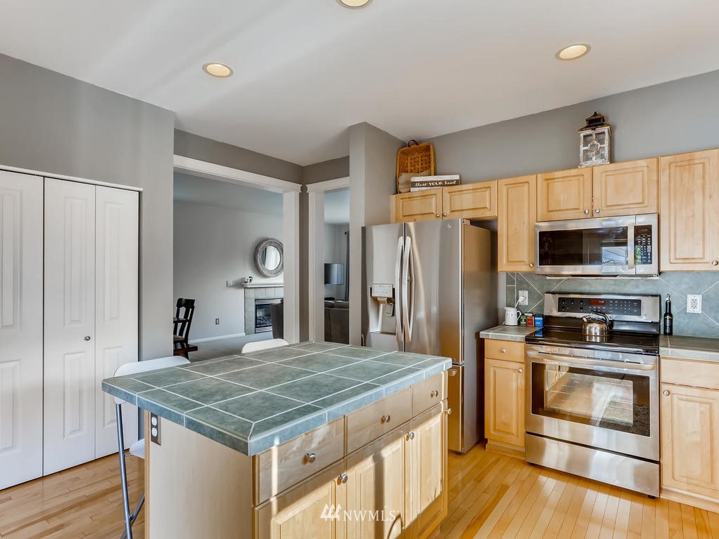 16624 Southeast 169th Street Renton, WA 98058 - Photo 9 of 21 a kitchen with kitchen island granite countertop a stove a sink and a refrigerator