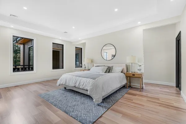 a bedroom with a large bed and wooden floor