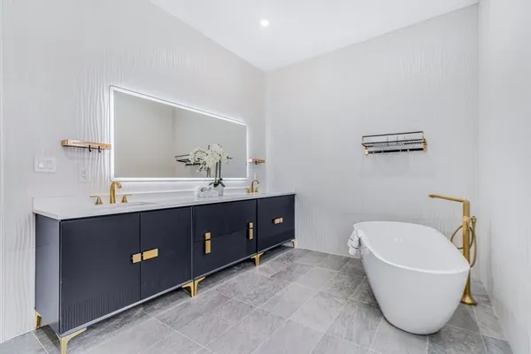a bathroom with a tub sink and mirror