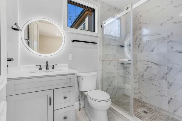 a bathroom with a sink a toilet and a mirror