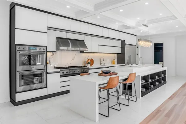 a kitchen with stainless steel appliances kitchen island granite countertop a stove and a sink