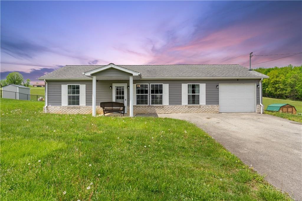 a front view of a house with a garden and yard