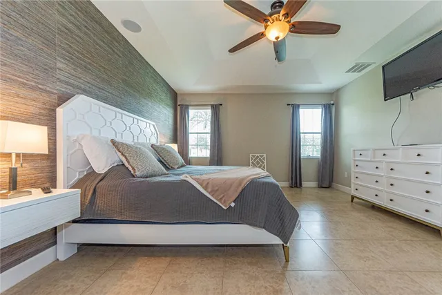 a spacious bedroom with a bed and a flat screen tv