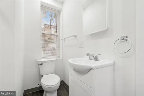 a bathroom with a sink toilet and a mirror