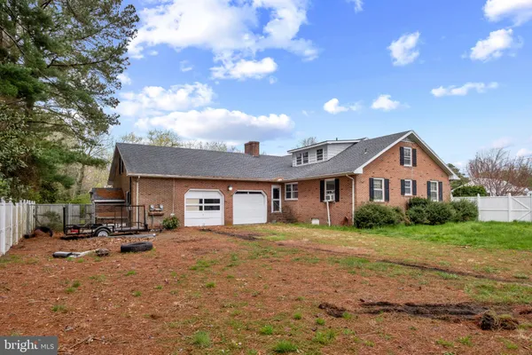 a view of a house with a big yard and large trees