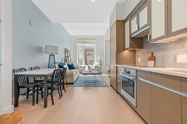 a kitchen with stainless steel appliances granite countertop a stove a sink a dining table and chairs