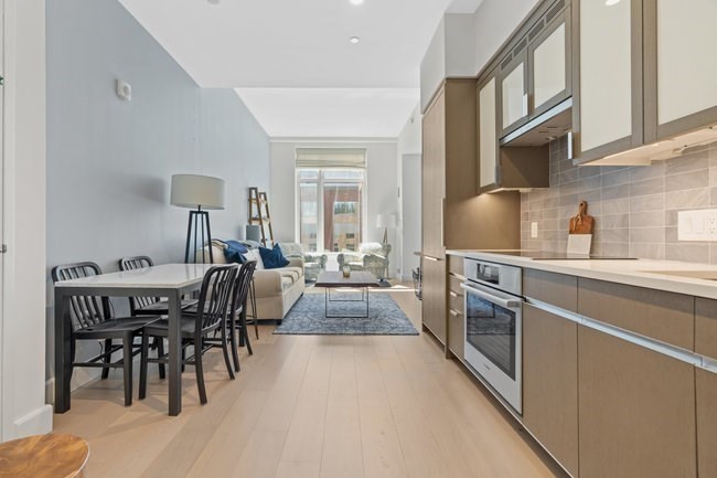 100 Lovejoy Place, Unit 12Q Boston, MA 02114 - Photo 3 of 13 a kitchen with stainless steel appliances granite countertop a stove a sink a dining table and chairs