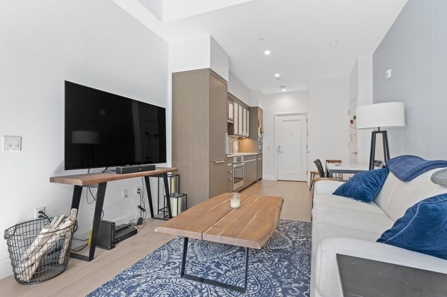 100 Lovejoy Place, Unit 12Q Boston, MA 02114 - Photo 5 of 13 a living room with furniture and a flat screen tv