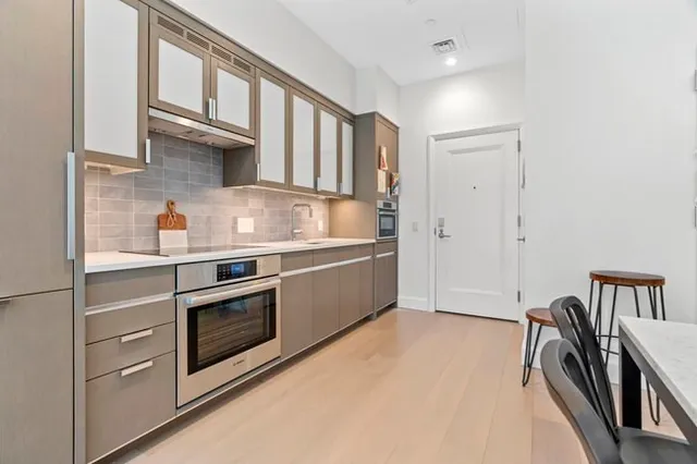 a kitchen with stainless steel appliances granite countertop a stove a sink and a refrigerator