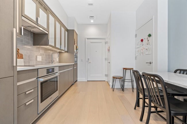 100 Lovejoy Place, Unit 12Q Boston, MA 02114 - Photo 7 of 13 a kitchen with stainless steel appliances kitchen island granite countertop a table chairs and cabinets