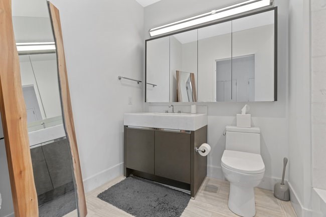 100 Lovejoy Place, Unit 12Q Boston, MA 02114 - Photo 10 of 13 a bathroom with a toilet a sink and a mirror