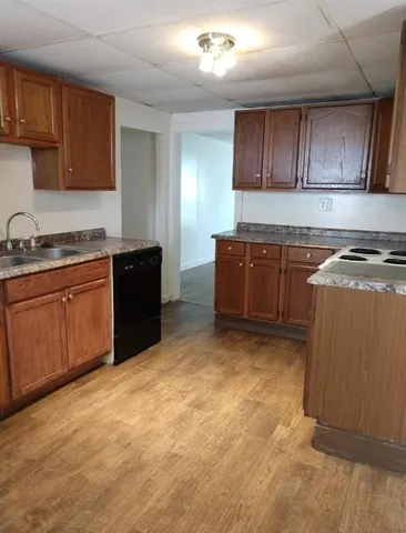 a kitchen with granite countertop a stove top oven sink and cabinets
