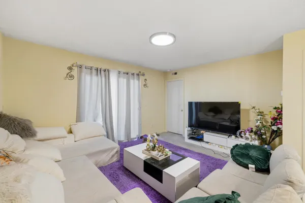 a living room with furniture and a gym machine