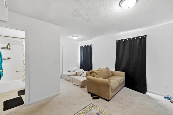 a living room with furniture and a white wall