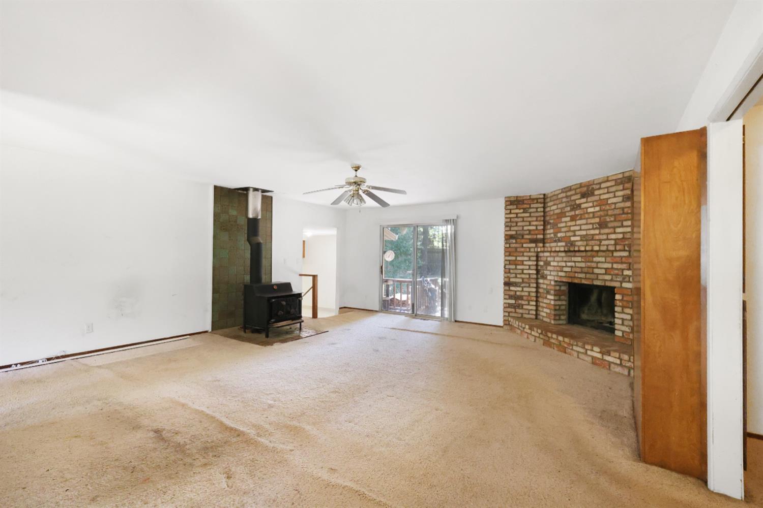 19688 Murphy Road Pine Grove, CA 95665 - Photo 2 of 8 an empty room with furniture and a fireplace