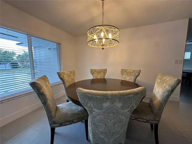 a view of a dining room with furniture a chandelier and wooden floor