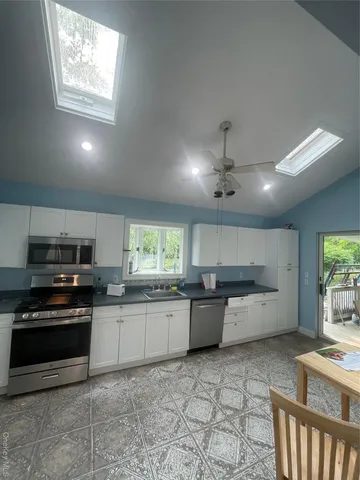 a kitchen with lots of counter top space appliances and a window