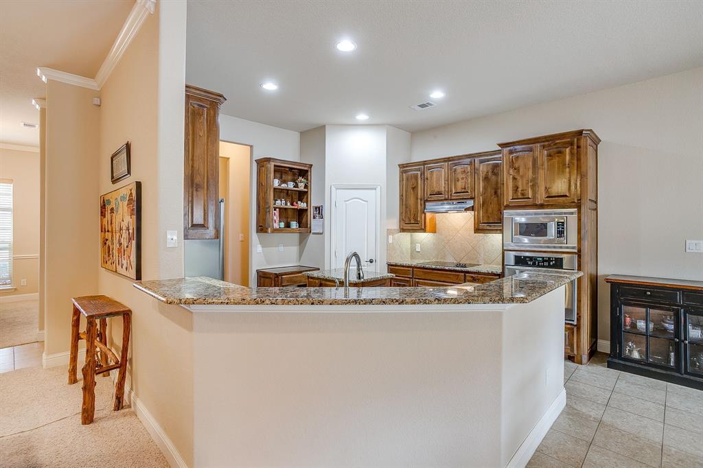 9815 Ravenswood Road Granbury, TX 76049 - Photo 12 of 40 a kitchen with stainless steel appliances granite countertop a sink and a refrigerator