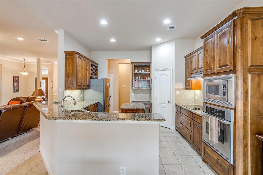 9815 Ravenswood Road Granbury, TX 76049 - Photo 13 of 40 a kitchen with stainless steel appliances granite countertop a refrigerator and a stove