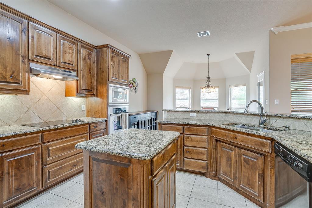 9815 Ravenswood Road Granbury, TX 76049 - Photo 16 of 40 a kitchen with stainless steel appliances granite countertop a sink and cabinets