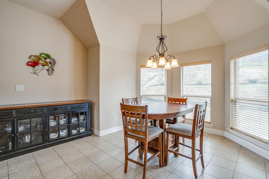 9815 Ravenswood Road Granbury, TX 76049 - Photo 18 of 40 a dining room with furniture a chandelier and wooden floor