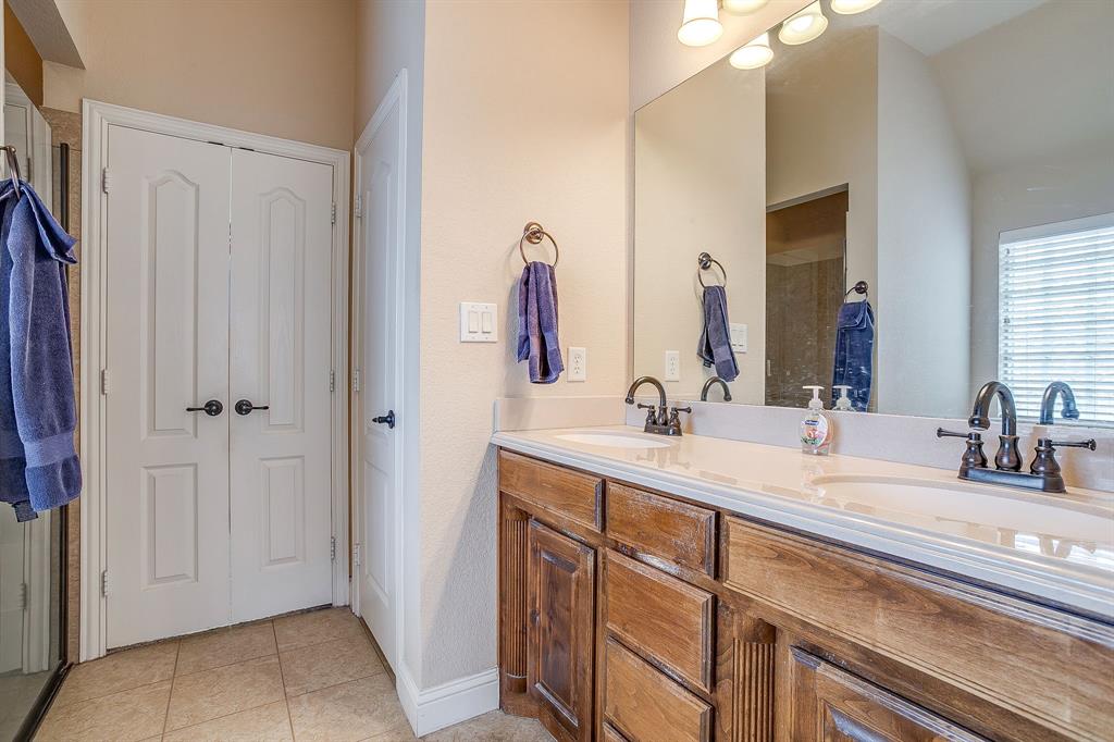 9815 Ravenswood Road Granbury, TX 76049 - Photo 22 of 40 a bathroom with a double vanity sink and a mirror