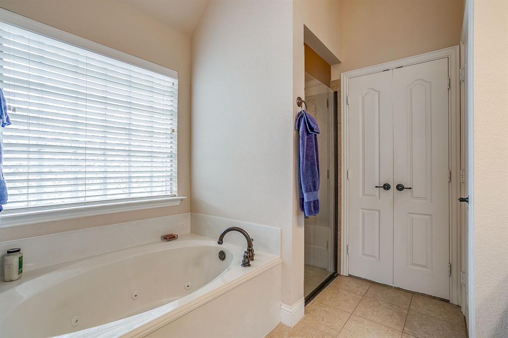 9815 Ravenswood Road Granbury, TX 76049 - Photo 23 of 40 a bathroom with a tub shower and a sink