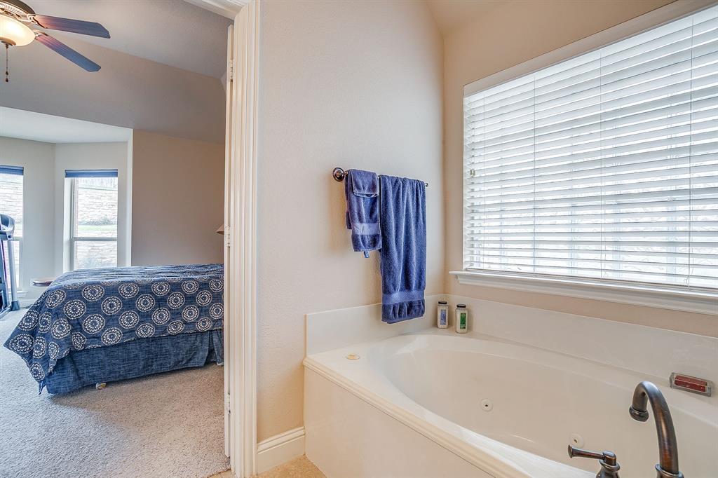 9815 Ravenswood Road Granbury, TX 76049 - Photo 25 of 40 a bathroom with a bathtub and a window
