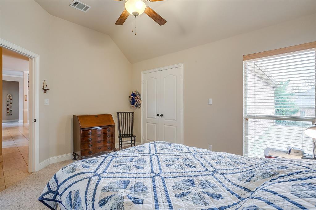 9815 Ravenswood Road Granbury, TX 76049 - Photo 30 of 40 a bedroom with a bed and a chandelier