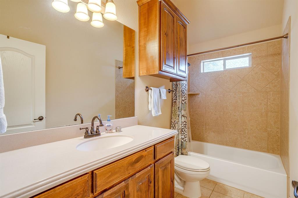 9815 Ravenswood Road Granbury, TX 76049 - Photo 31 of 40 a bathroom with a sink a toilet and shower