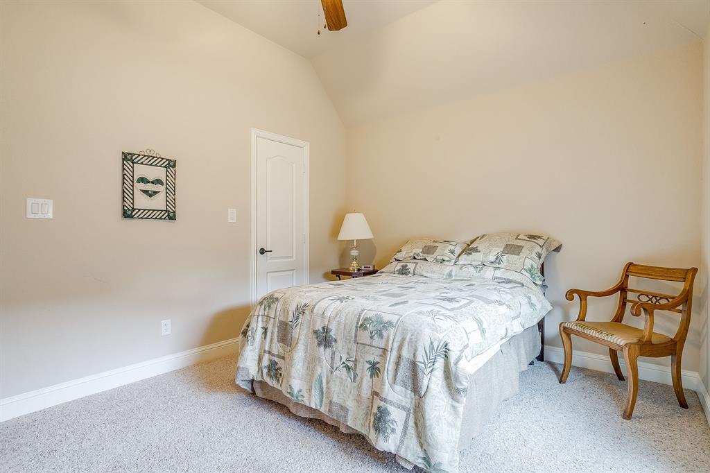 9815 Ravenswood Road Granbury, TX 76049 - Photo 33 of 40 a bedroom with a bed and chair