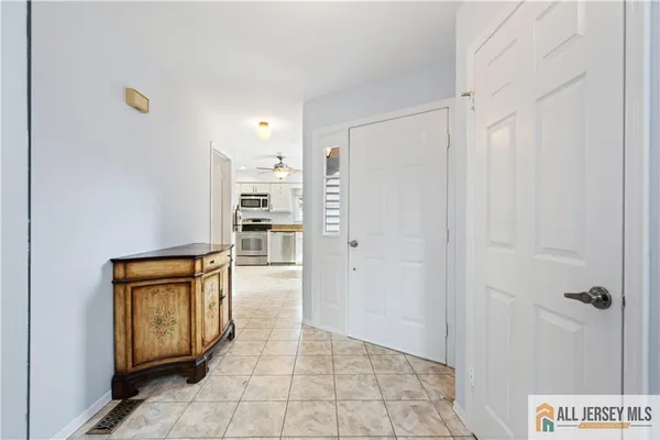 a view of a hallway to an empty room with a window