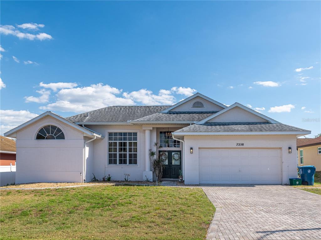 a view of a house with a yard and garage
