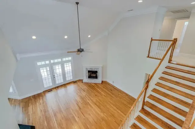 a view of an empty room with window and wooden floor
