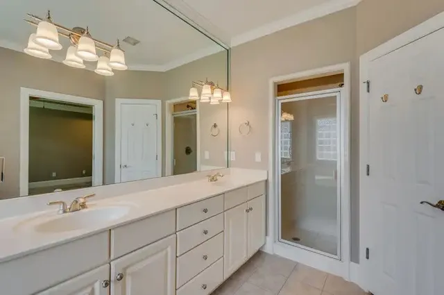 a bathroom with double vanity sinks and a mirror