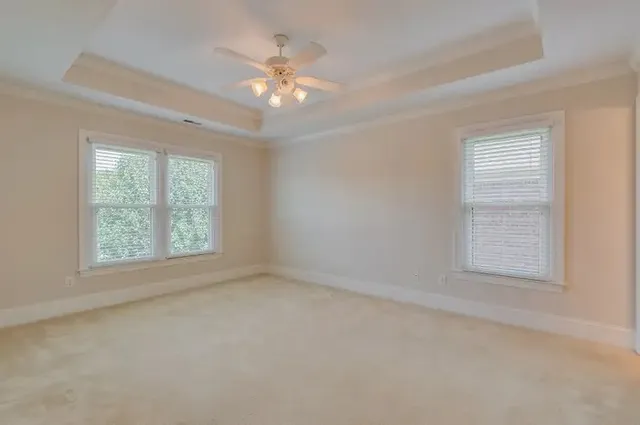 an empty room with a window and a fan