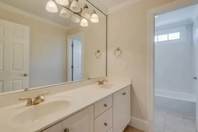 a bathroom with a bathtub a sink and a window