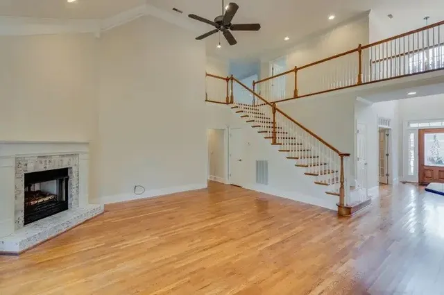 a view of a livingroom with wooden floor and a fireplace
