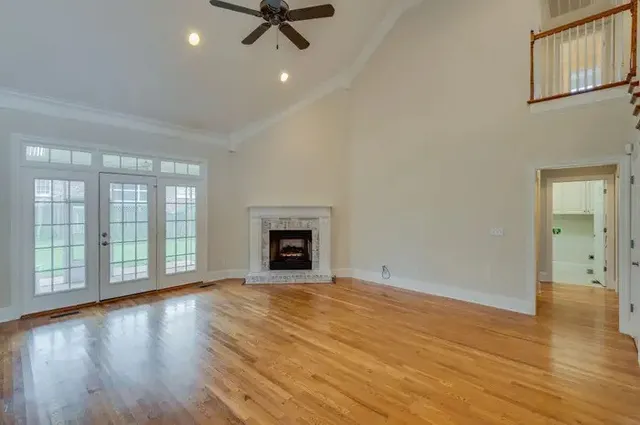 wooden floor fireplace and windows in an empty room