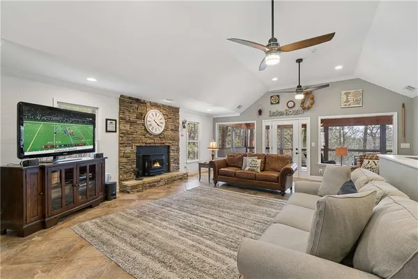 a kitchen with stainless steel appliances granite countertop a sink a stove a refrigerator and chairs