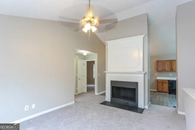 a view of a livingroom with a fireplace and a chandelier fan
