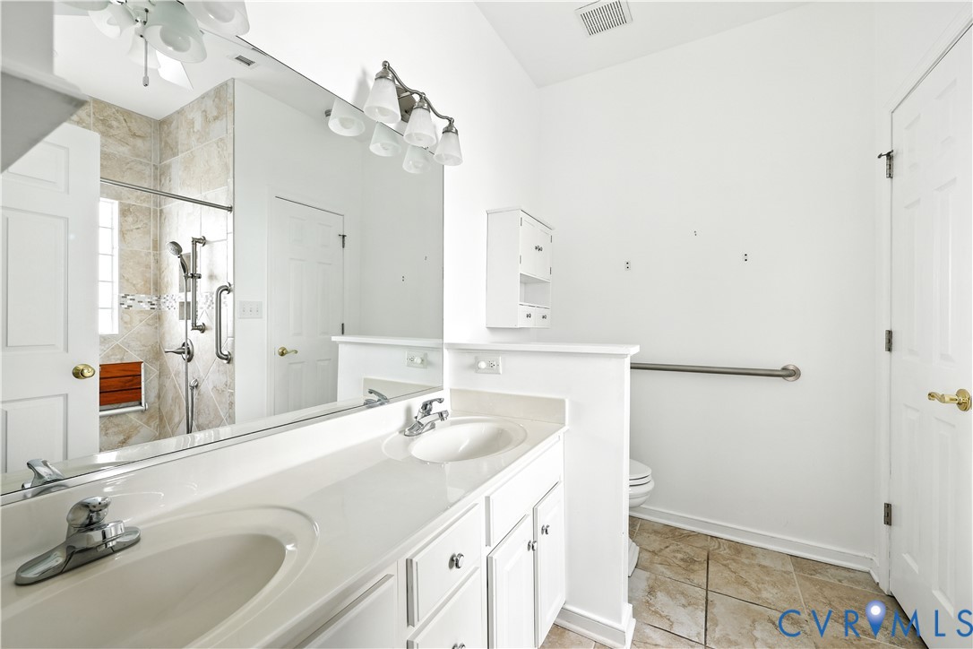 695 Krim Point Loop Midlothian, VA 23114 - Photo 20 of 29 Bathroom with double vanity, a tile shower, and li