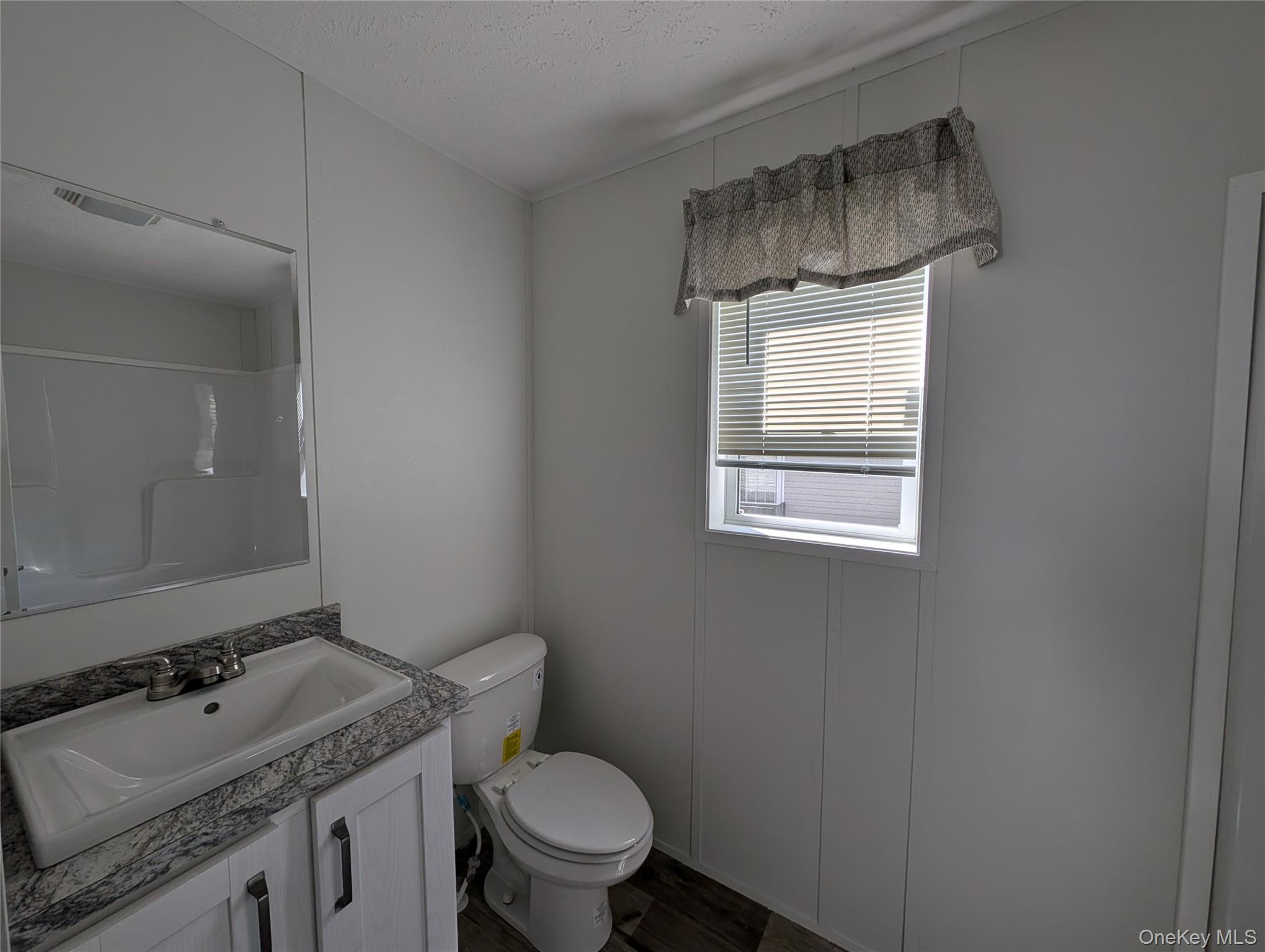 3146 Rte 9W, Unit 8A New Windsor, NY 12553 - Photo 10 of 14 a bathroom with a granite countertop sink toilet and mirror