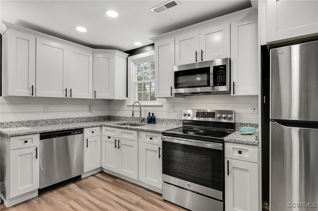 206 West McClellan Street Sandston, VA 23150 - Photo 12 of 24 a kitchen with granite countertop white cabinets and stainless steel appliances