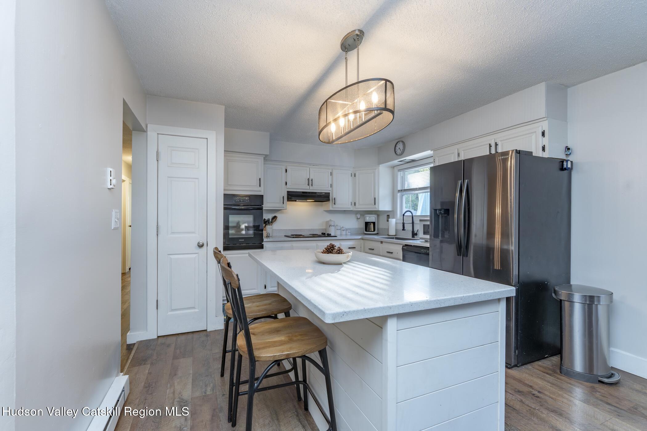 30 Willow Road Saugerties, NY 12477 - Photo 14 of 40 a kitchen with stainless steel appliances a dining table chairs refrigerator and microwave
