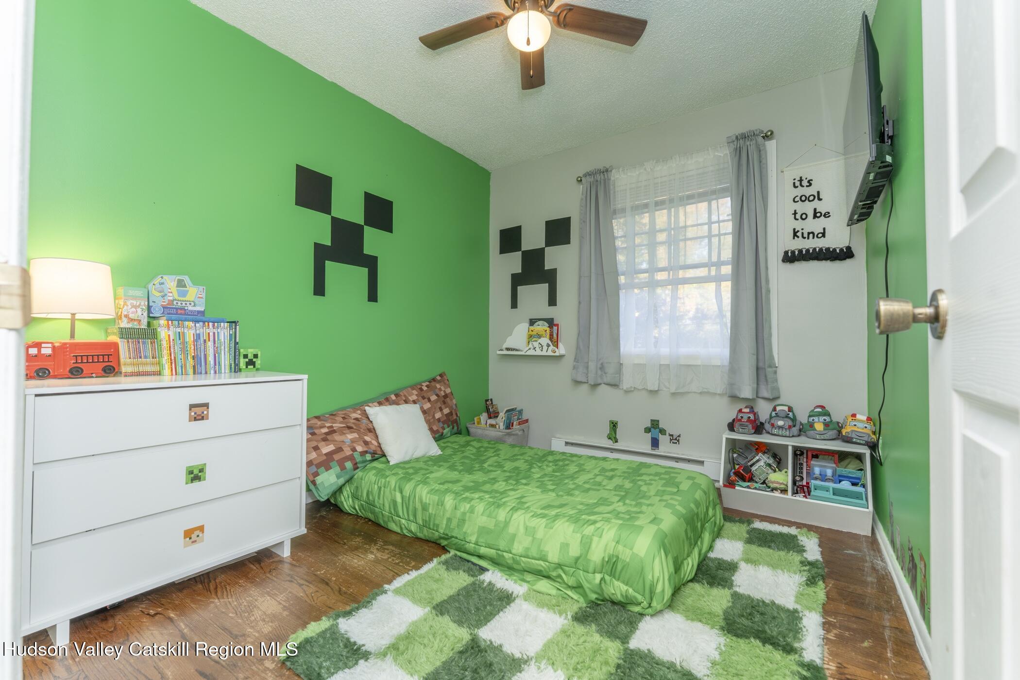 30 Willow Road Saugerties, NY 12477 - Photo 22 of 40 a bedroom with a bed and a chandelier fan