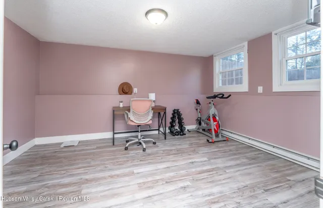 a view of a workspace with furniture and a window